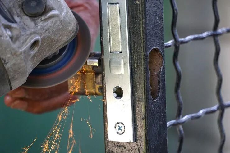 Close-up of a commercial gate deadbolt being repaired by a licensed locksmith in Orange County CA