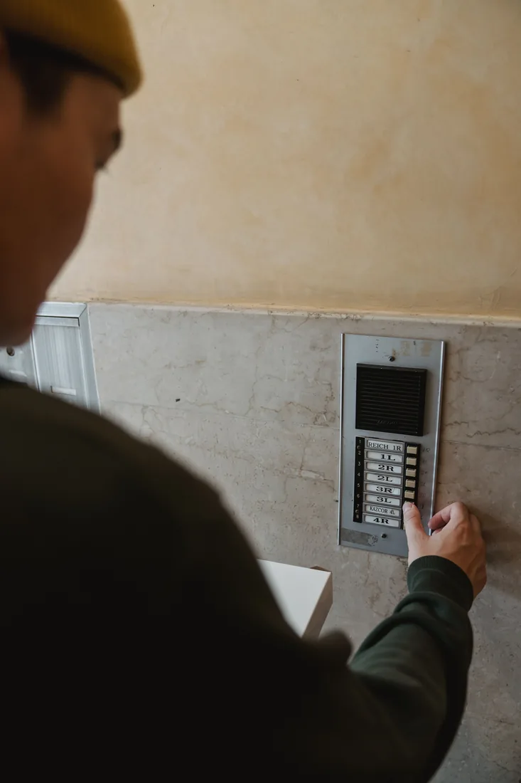 Person entering a code on a building security keypad