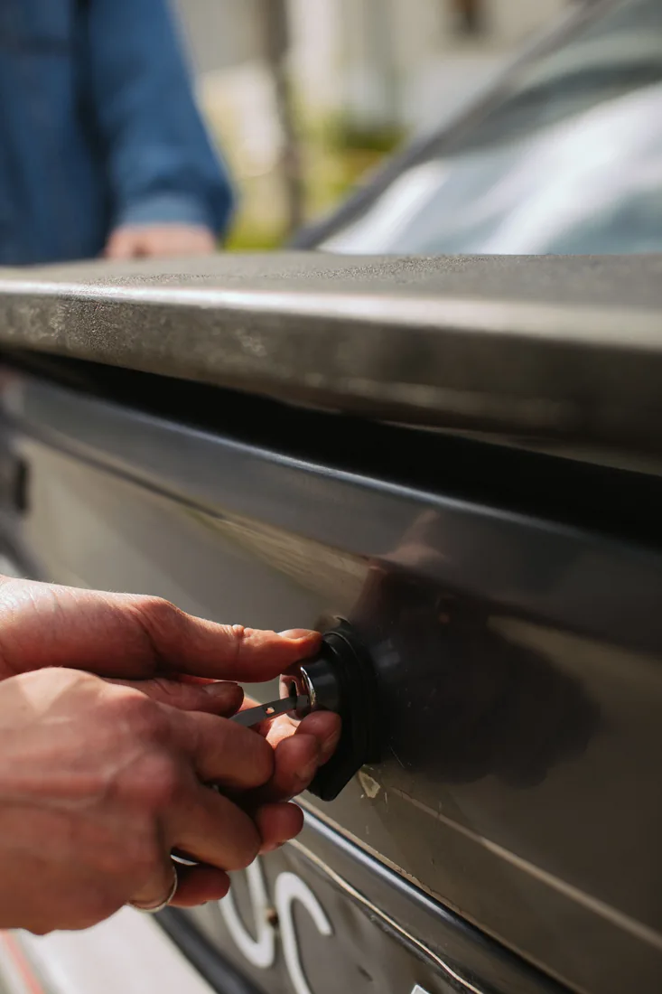 Hand unlocking a car door with a key