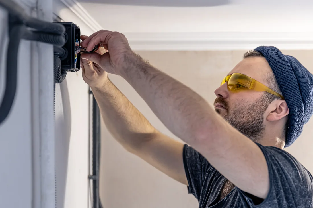 Technician mounting a device on an interior wall