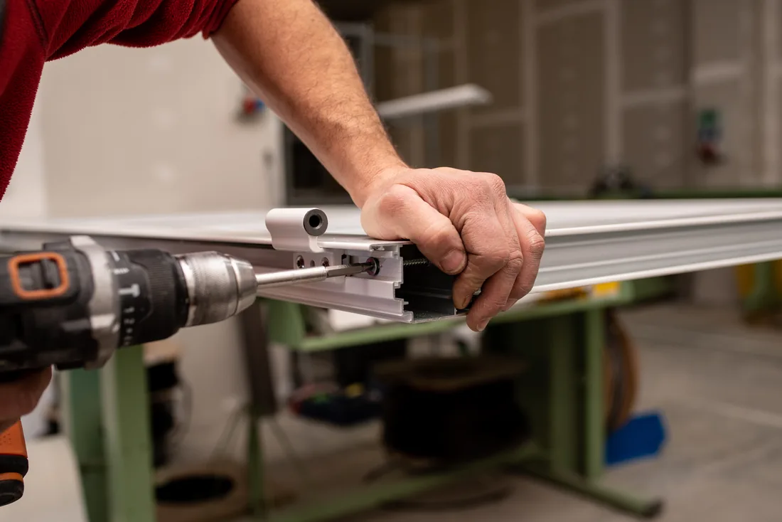 Technician machining a metal door profile