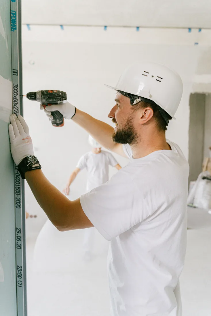 Technician drilling a door to fit a deadbolt