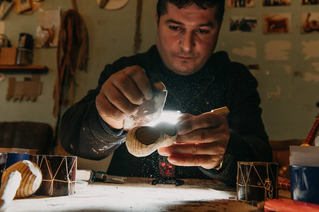 Craftsman doing precision work under a bright lamp