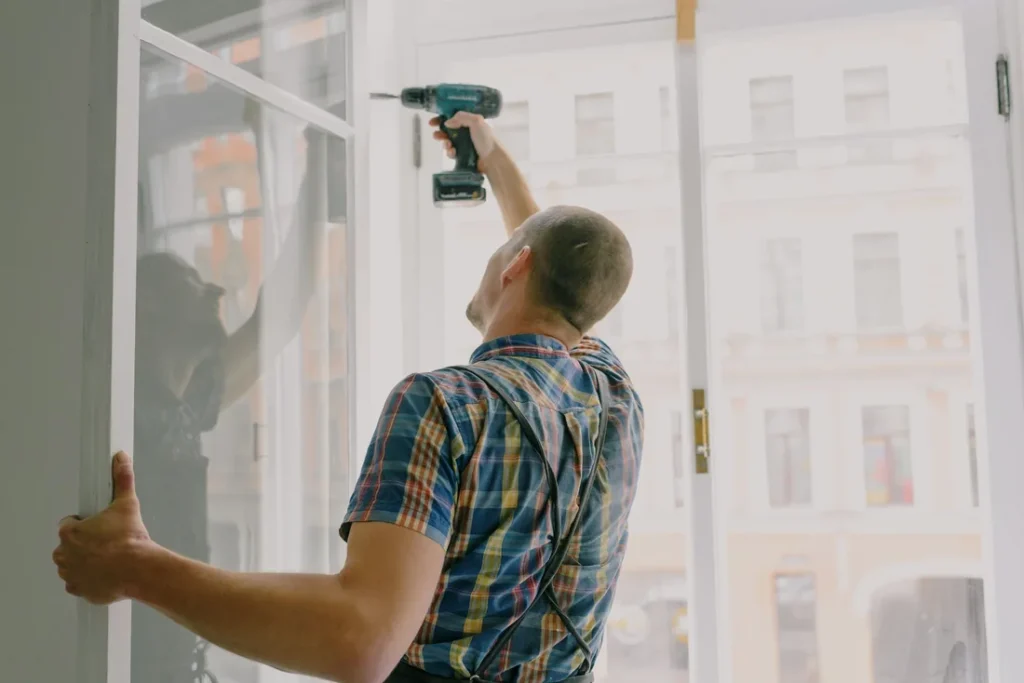 Locksmith Garden Grove Technician repairing a sliding door frame with a power drill