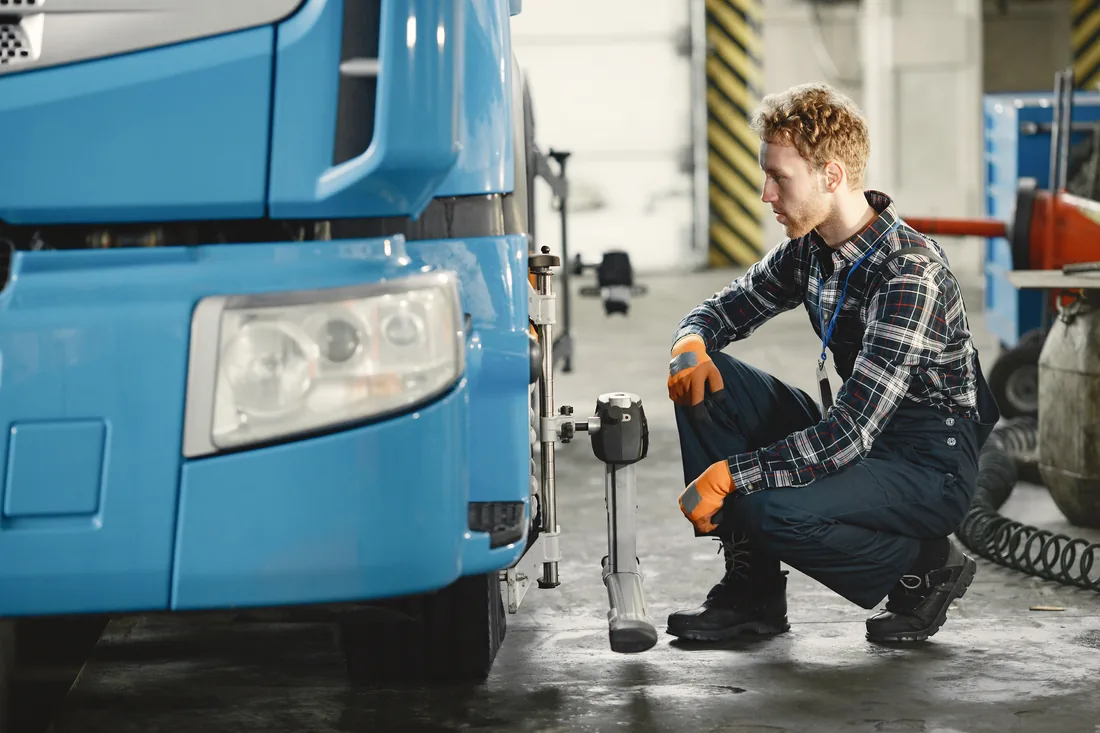 Technician servicing a commercial truck in a workshop